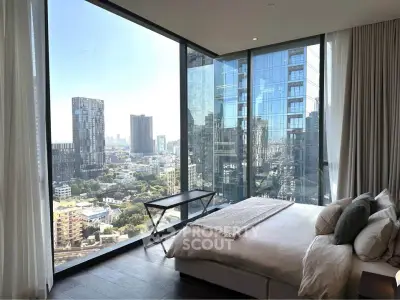 Luxurious bedroom with floor-to-ceiling windows offering stunning city views in a modern high-rise apartment.