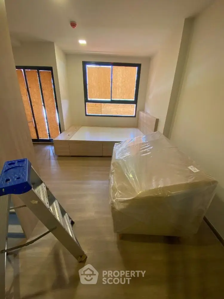 Spacious bedroom with modern furniture and large window, perfect for natural light.