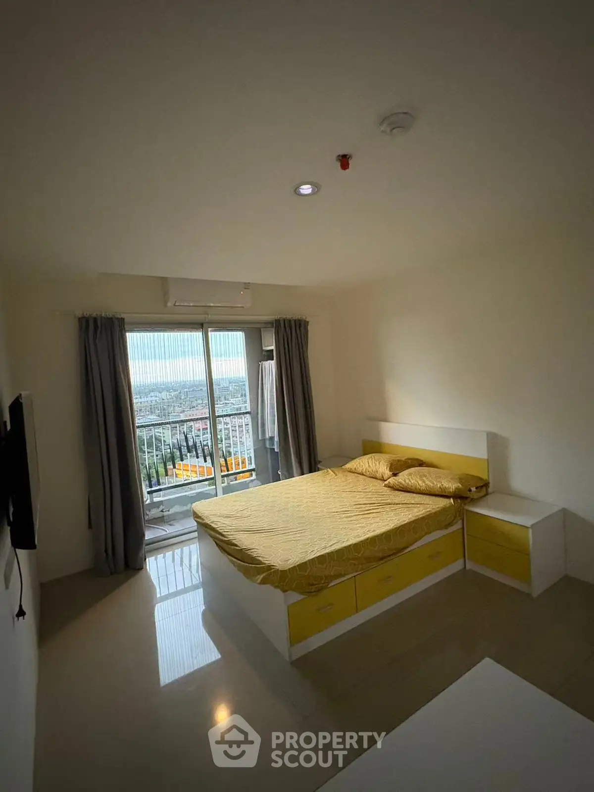 Modern bedroom with balcony and city view in high-rise apartment