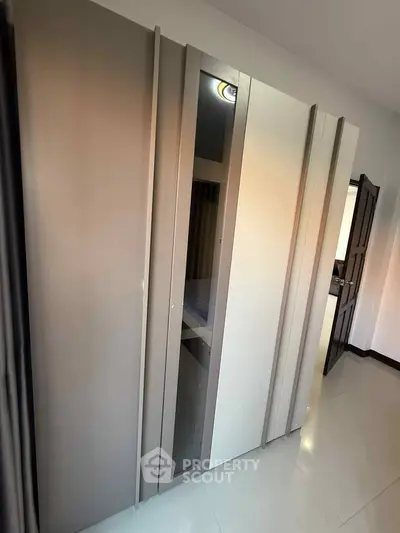 Modern wardrobe with sleek design in a contemporary bedroom setting.