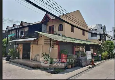 Charming corner unit with unique architecture and lush greenery in a vibrant neighborhood.