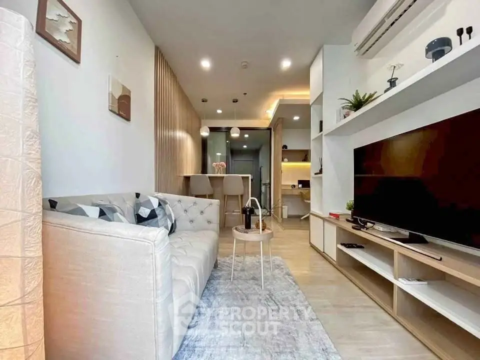 Modern living room with stylish decor and open layout, featuring a cozy sofa and large TV unit.