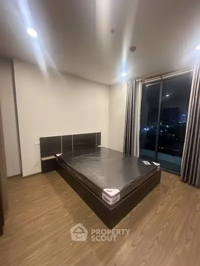 Modern bedroom with city view and sleek wooden flooring