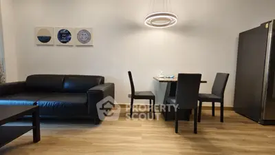 Modern living room with sleek black furniture and stylish lighting, perfect for contemporary living.