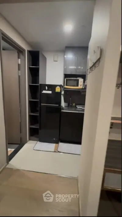 Compact modern kitchen with sleek black appliances and open shelving