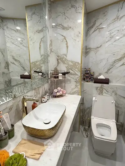 Luxurious marble bathroom with elegant gold sink and modern fixtures