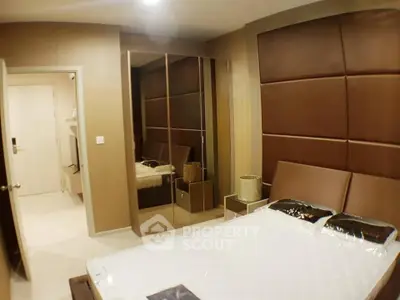 Luxurious bedroom with modern design and mirrored wardrobe in upscale apartment.