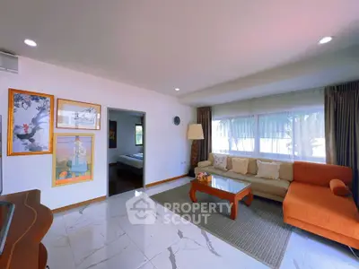 Spacious living room with modern decor and large windows offering natural light.