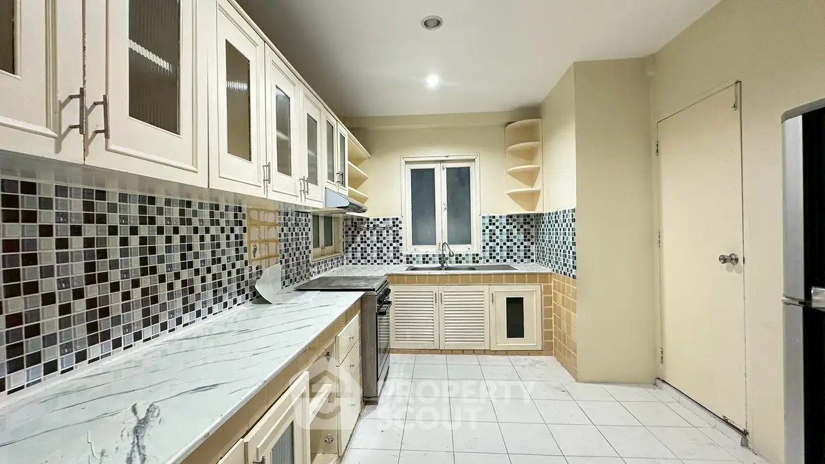 Spacious kitchen with modern cabinetry and stylish tile backsplash