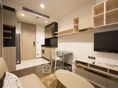 Modern living room with sleek furniture and open kitchen layout in a stylish apartment.