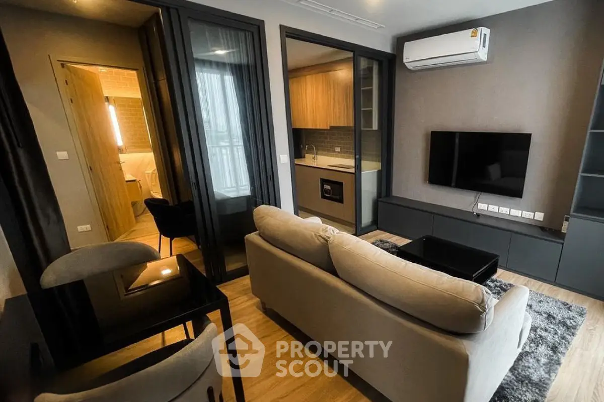 Modern living room with open kitchen and stylish decor in a cozy apartment.