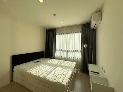 Spacious bedroom with modern furnishings and natural light in a stylish apartment.