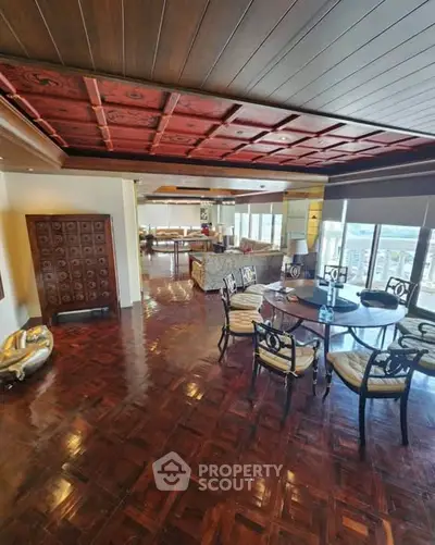 Luxurious living room with elegant wooden ceiling and polished floors, offering a spacious and inviting atmosphere.