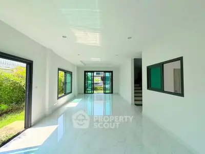 Spacious modern living room with large windows and garden view