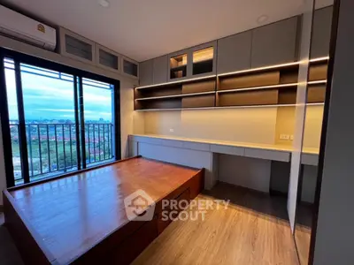 Modern bedroom with built-in storage and stunning city view from balcony.