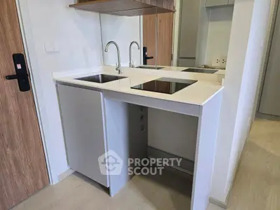 Modern compact kitchen with sleek design and induction cooktop in a stylish apartment.