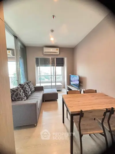 Modern living room with cozy sofa and dining area, featuring natural light and stylish decor.