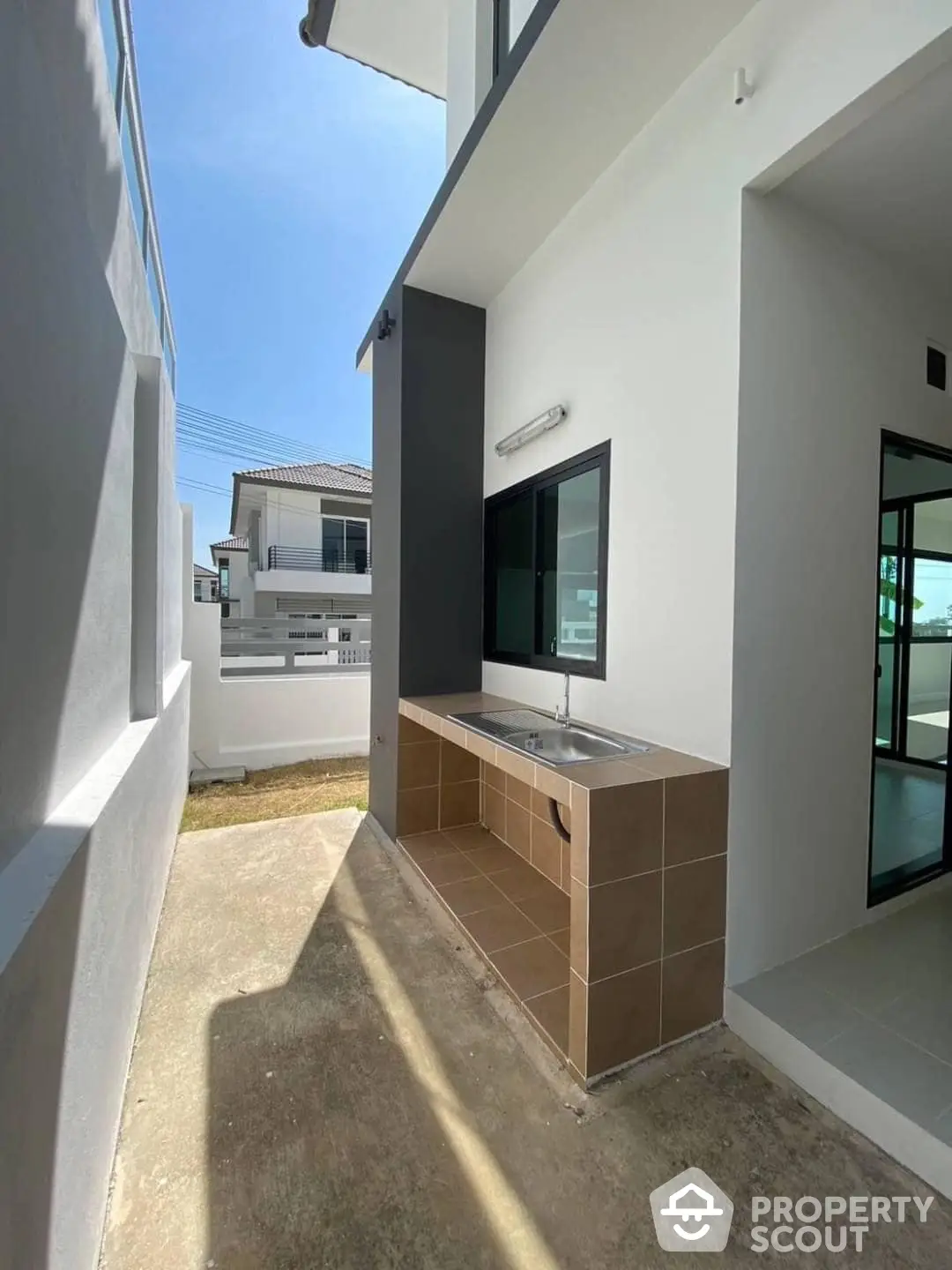 Modern outdoor kitchenette on a sunny patio with sleek finishes, perfect for al fresco dining and entertaining in a contemporary home setting.