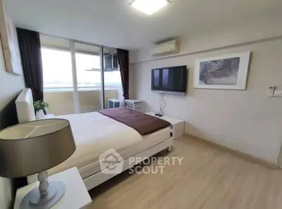 Modern bedroom with balcony access and wall-mounted TV in a stylish apartment.