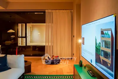 Modern living room with stylish decor and large TV, showcasing cozy ambiance.