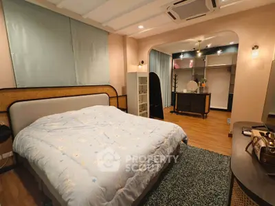 Spacious bedroom with modern decor and cozy ambiance, featuring a large bed and stylish furnishings.