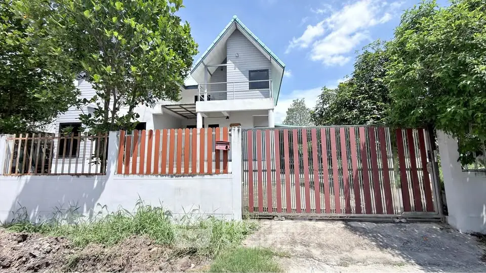 Charming two-story house with modern design and lush greenery, perfect for family living.