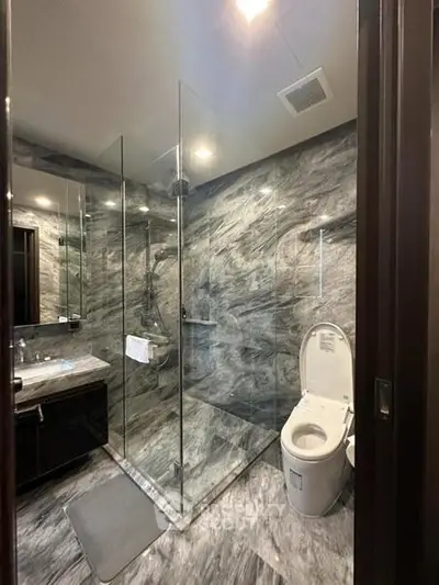 Luxurious modern bathroom with marble walls and glass shower enclosure