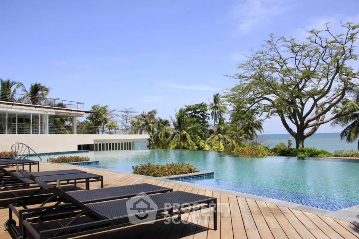 Luxurious beachfront infinity pool with ocean view and lush tropical landscaping.