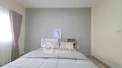 Cozy bedroom with modern decor and natural light, perfect for relaxation.