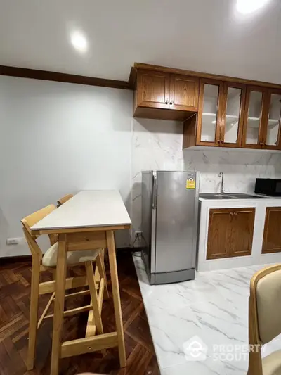 Modern kitchen with wooden cabinets and sleek refrigerator in stylish apartment