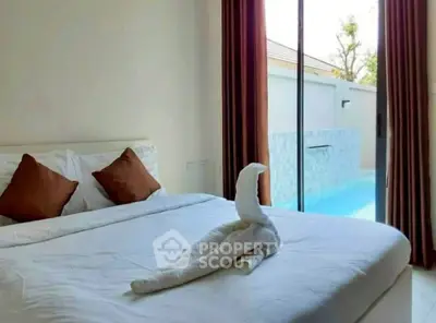 Luxurious bedroom with pool view, elegant decor, and natural light.