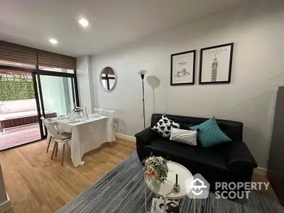 Chic modern living space with sleek black sofa, elegant dining set, and access to a cozy balcony, perfect for urban living and entertaining guests.