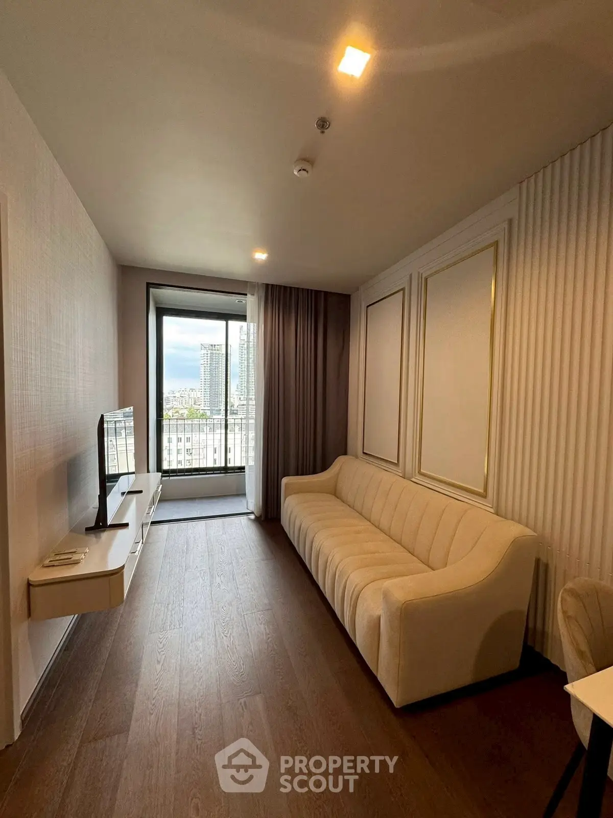 Modern living room with elegant sofa and city view balcony, perfect for urban living.