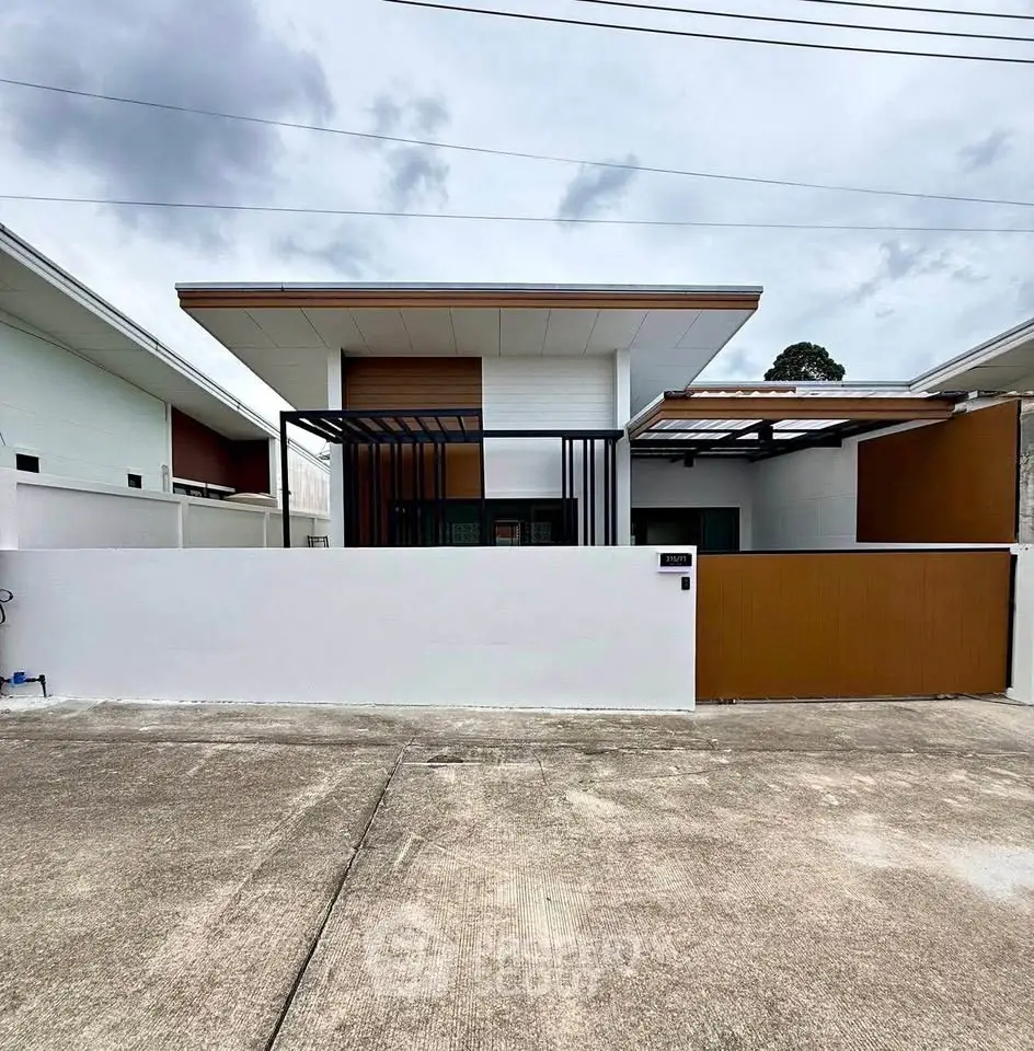 Modern minimalist house exterior with sleek design and clean lines, featuring a gated entrance and spacious driveway.
