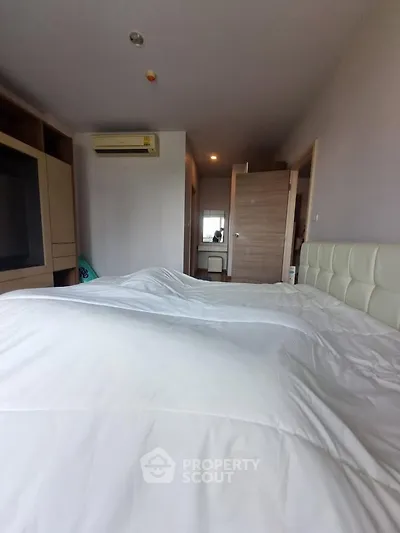 Spacious bedroom with modern furnishings and air conditioning in a stylish apartment.