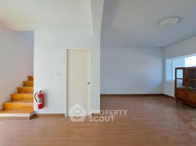 Spacious interior with wooden flooring and staircase, ideal for modern living.