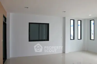Spacious modern living room with large windows and minimalist design.