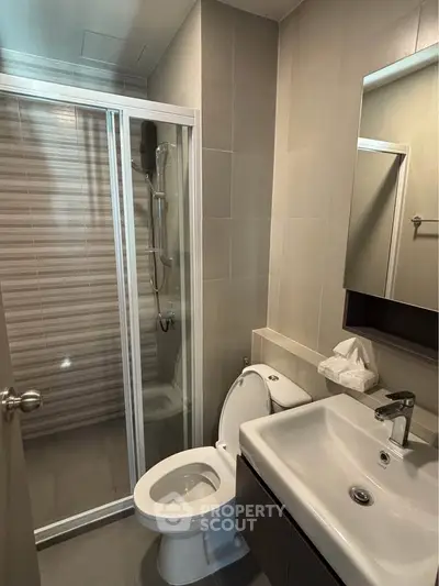 Modern bathroom with glass shower and sleek fixtures in a contemporary apartment.