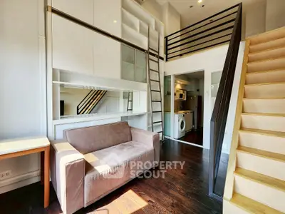 Modern loft apartment with mezzanine, cozy sofa, and washing machine in bright interior.
