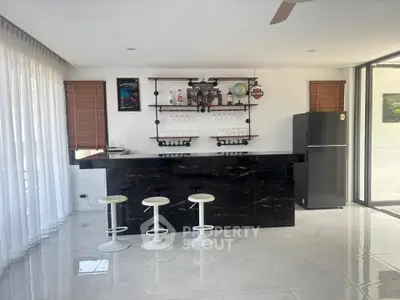 Modern kitchen with sleek black marble counter and bar stools