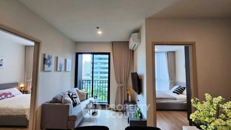 Modern apartment with open living room and two bedrooms, featuring a cozy balcony view.