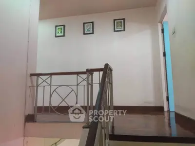 Charming staircase with wooden flooring and elegant railing in a cozy home interior.