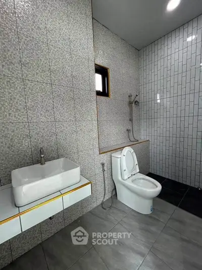 Modern bathroom with sleek tiles and contemporary fixtures in a stylish real estate property.