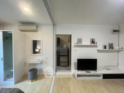 Modern living room with sleek design, featuring a TV unit, air conditioning, and stylish decor.