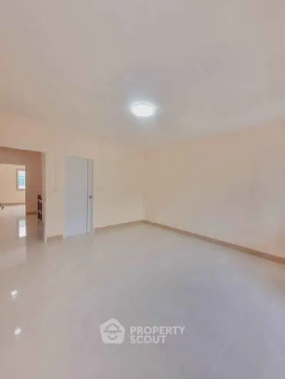 Spacious empty room with glossy tiled flooring and bright lighting, ideal for customization.