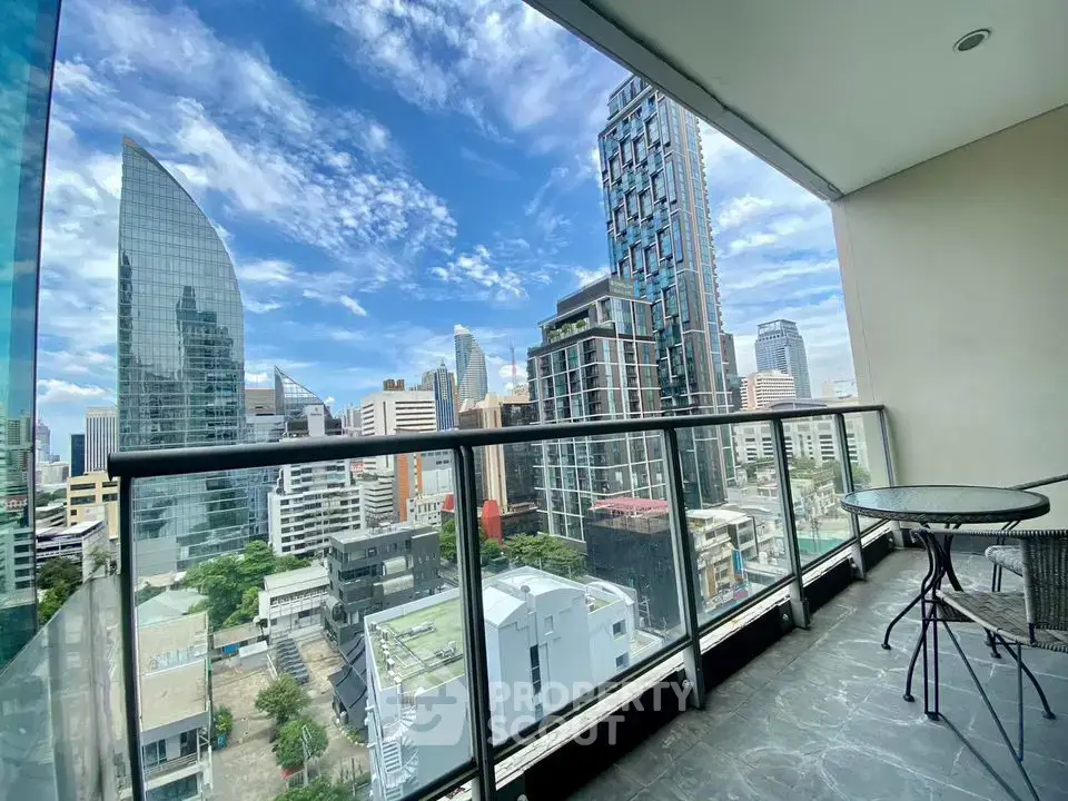 Stunning cityscape view from a modern high-rise balcony with glass railing.