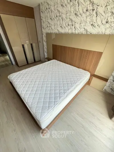 Modern bedroom with stylish wood accents and marble-patterned wall.