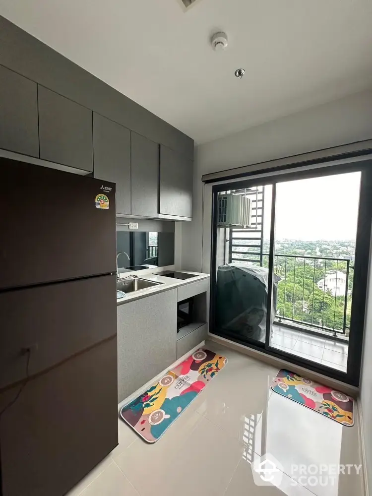 Modern kitchen with balcony view in high-rise apartment