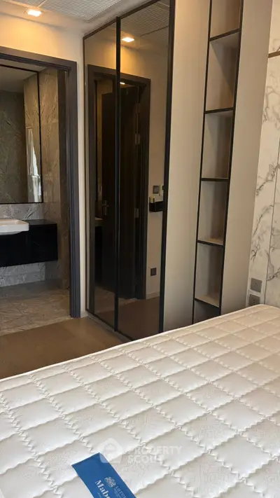 Modern bedroom with mirrored closet doors and ensuite bathroom