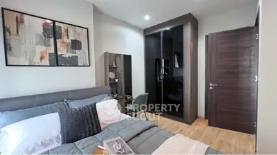 Modern bedroom with stylish decor and cozy atmosphere, featuring a sleek wardrobe and elegant furnishings.